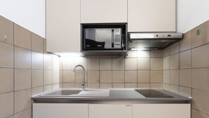 A modern kitchen with a built-in microwave, stainless steel sink, and a range hood. - Nice apartment for 4 guests with A/C, WIFI, terrace and pets allowed (Marina Di Andora)