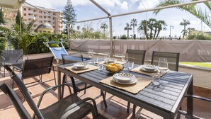 An outdoor dining area with a table set for two, surrounded by chairs, under a canopy. - Nice apartment for 4 guests with A/C, WIFI, terrace and pets allowed (Marina Di Andora)