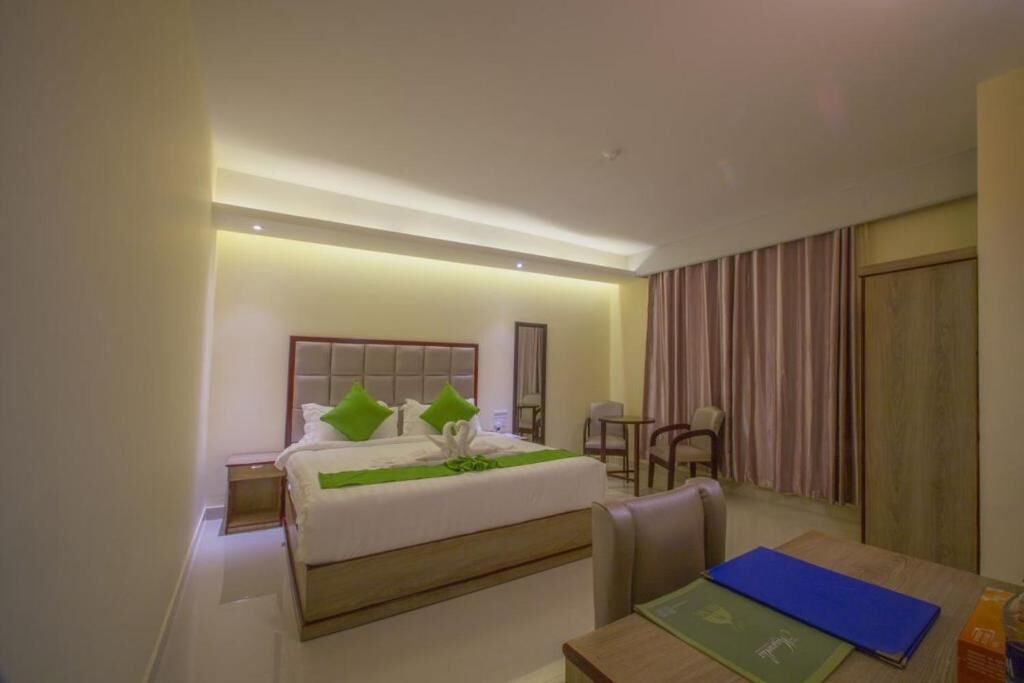 A hotel room with a bed, a desk, and a chair.
