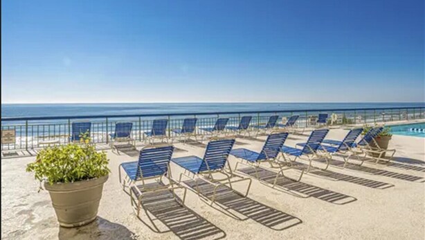 Un salon de plage avec des chaises longues et vue sur l’océan.