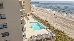Un hôtel doté d’une piscine sur le toit, offrant une vue sur la plage.