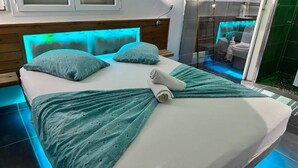 Ein modernes Schlafzimmer mit einem Bett, Kissen und einem zusammengerollten Handtuch.