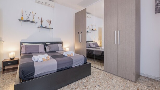 A modern bedroom with a large bed, a wardrobe, and a mirror. - Basilica of St. John Lateran • 1Bedr - 5 minutes Station A/C (Roma)