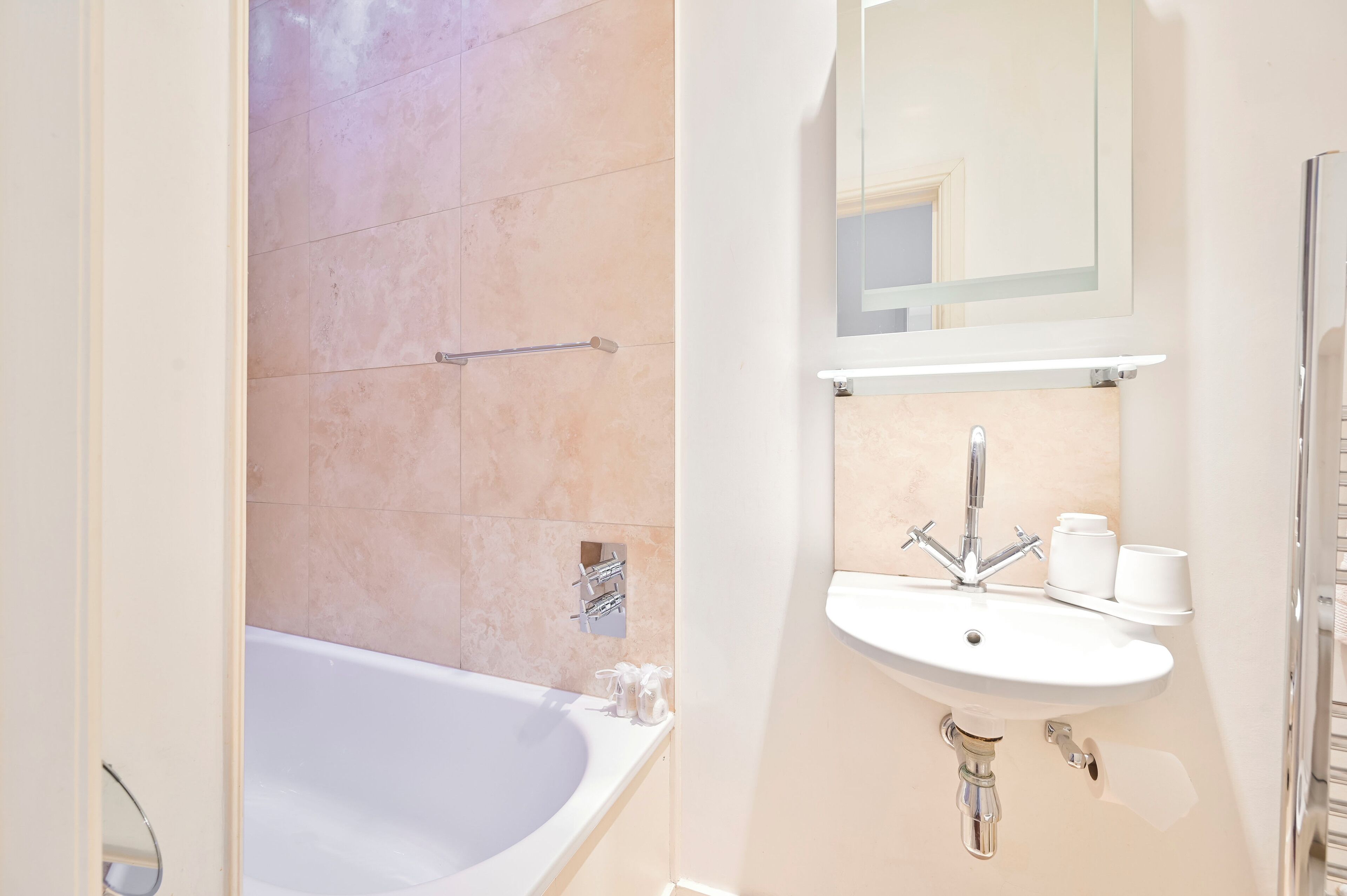 Une salle de bain moderne avec une baignoire, un lavabo et un miroir.