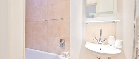 Une salle de bain moderne avec une baignoire, un lavabo et un miroir.