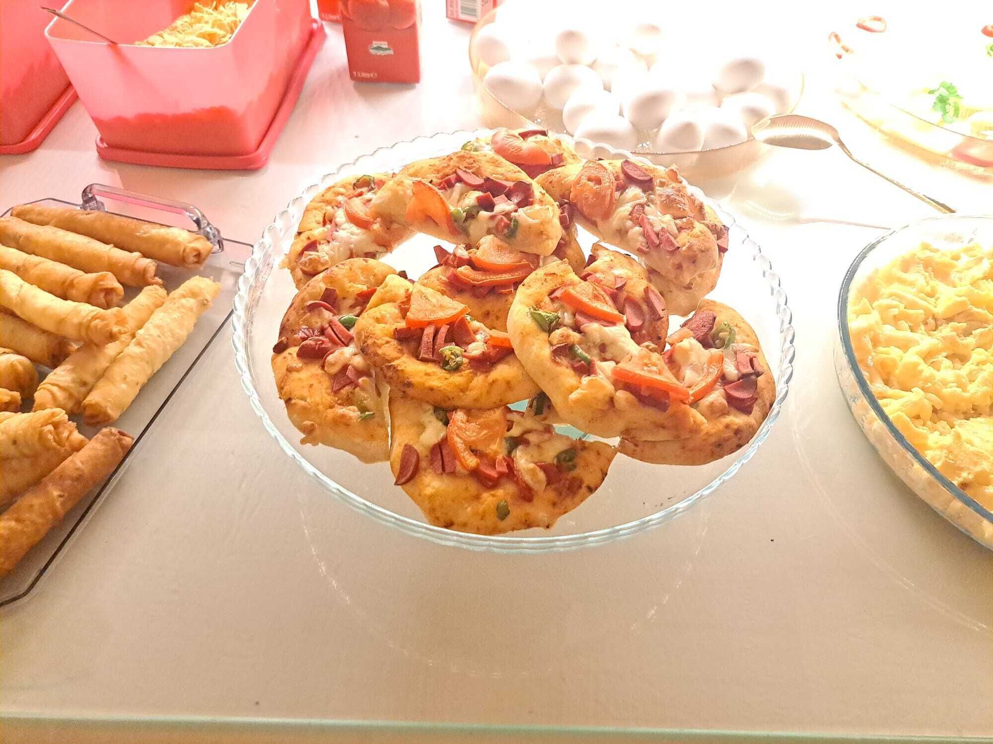 A buffet table with various dishes including fried items, a glass pie, and a red container.