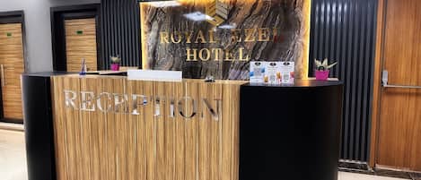 A reception desk with a marble backdrop and the text "ROYAL AZTECA HOTEL".