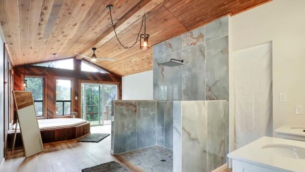 Ein modernes Badezimmer mit Dusche, Badewanne und einem großen Spiegel.