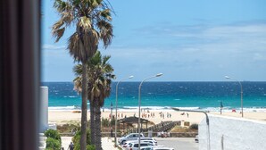 Vista de una playa con palmeras, arena y un océano azul cristalino.