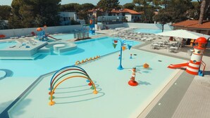 Une piscine avec des toboggans et un espace de jeux pour enfants.