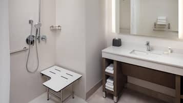 Ein modernes Badezimmer mit Dusche, Waschbecken und Spiegel.