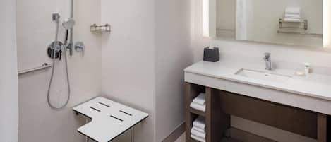 Ein modernes Badezimmer mit Dusche, Waschbecken und Spiegel.