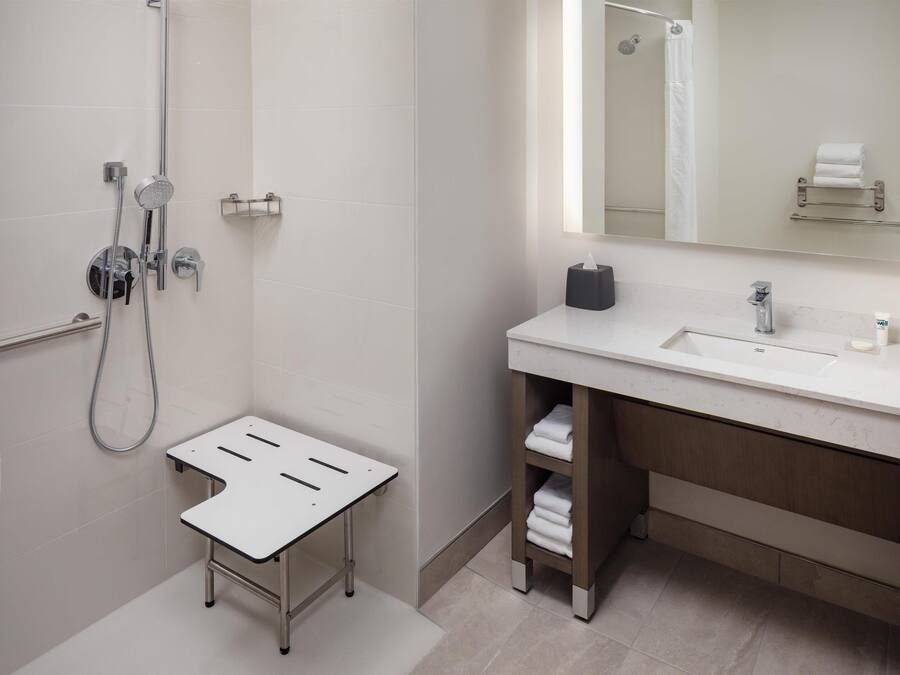 Ein modernes Badezimmer mit Dusche, Waschbecken und Spiegel.