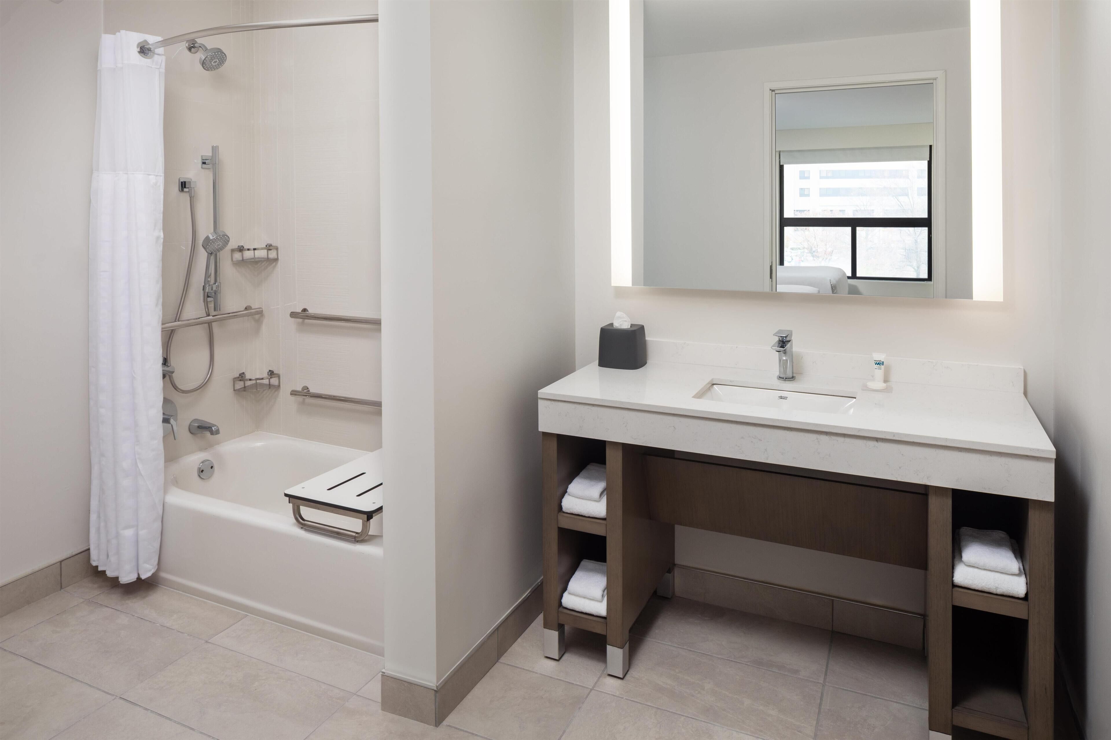A modern bathroom with a bathtub, a sink, and a mirror.