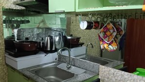 A kitchen with granite countertops, a sink, a stove, and various kitchen appliances. - Paseo Verde Condominium (Las Pinas)