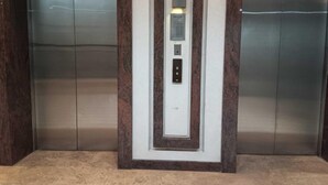 An elevator with a modern design, featuring a central control panel and a light above it. - Paseo Verde Condominium (Las Pinas)