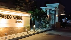 A well-lit hotel entrance with a sign reading "PASEO VERDE OR REAL". - Paseo Verde Condominium (Las Pinas)