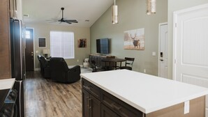 A spacious kitchen with a large island, dark wood flooring, and a ceiling fan. - Cougar Canyon Unit A (Heber-Overgaard)