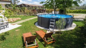 A hot tub surrounded by a garden with a wooden deck, a ladder, and a stone wall. - Dèpendance - Lequile - Alfa Country House (Lequile)