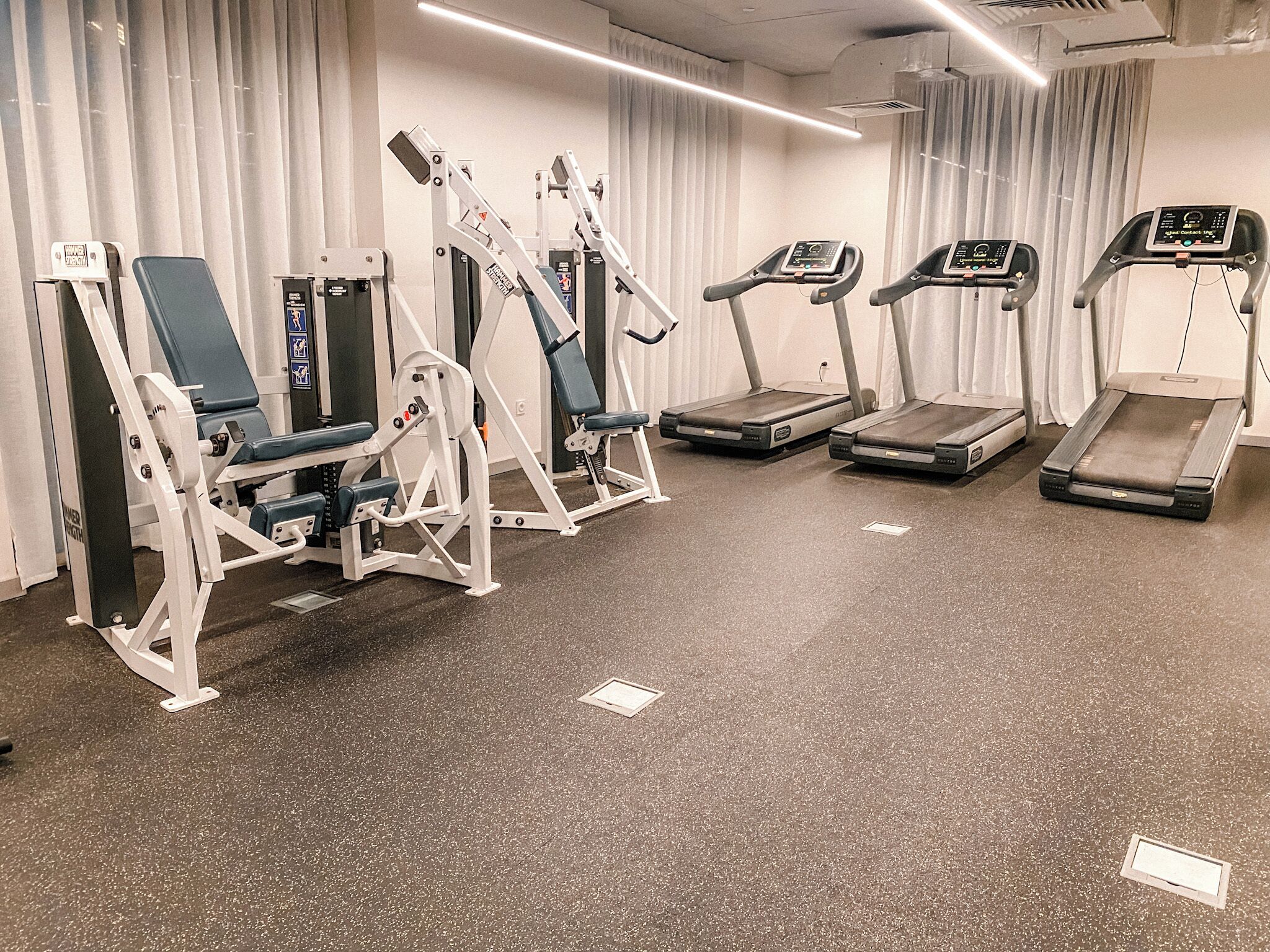 A gym with various exercise equipment including treadmills and weight machines.