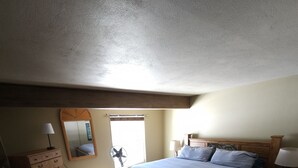 Un dormitorio con una cama grande, un aparador de madera y un espejo.