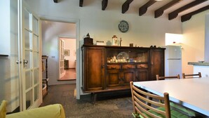 A kitchen with a wooden cabinet, a dining table, and chairs. - Beautiful private villa for 6 guests with WIFI, A/C, TV, patio and pets allowed (Cosio Valtellino)