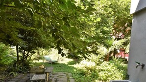 A garden with a stone bench, a table, and a small fountain. - Beautiful private villa for 6 guests with WIFI, A/C, TV, patio and pets allowed (Cosio Valtellino)