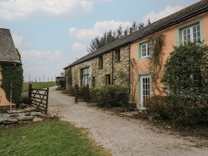 A rural property with stone buildings, a gravel driveway, and surrounding greenery. - Winder Green (Penrith)
