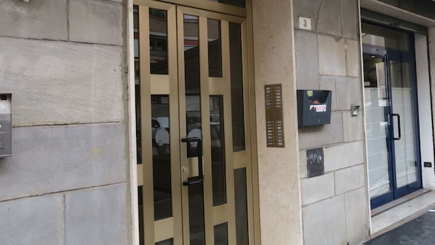 A building entrance with a beige door, a mailbox, and a glass door to the right. - Beautiful apartment for 4 guests with WIFI, A/C, TV and balcony (Bologna)