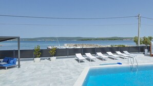 A rooftop pool with lounge chairs and a seating area, overlooking a body of water and distant land. - Beautiful apartment for 6 guests with private pool, A/C, WIFI, TV, patio and pets allowed (Zadar)