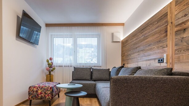 A modern living room with a sofa, ottoman, and coffee table.