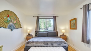 A bedroom with a bed, bedside tables, a fan, and a window. - Charming Arlington Home w/ Hot Tub & Fenced Yard! (Arlington)