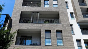 A multi-story building with a modern design, featuring balconies, large windows, and a ground entrance. - Maria (Bucharest)
