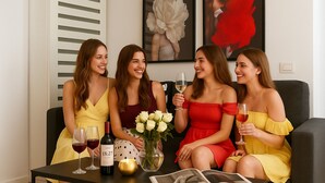 Four people seated at a table with wine glasses, a bottle of wine, and a candle. - Maria (Bucharest)