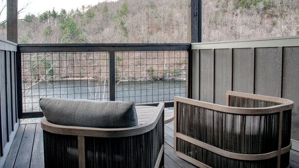 A wooden deck with a curved bench and a wooden planter. - Located on Bear Lake in Tuckasegee, NC.  A scenic getaway for your family event! (Tuckasegee)