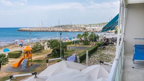 A view of a beach with a rocky breakwater, a playground, and a bar named "BAR RISTOGANO". - Lovely apartment for 6 people with A/C, WIFI, TV and balcony (Rosignano Solvay-castiglioncello)
