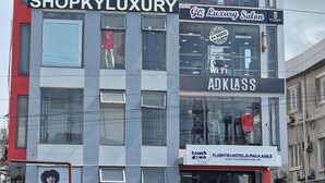 Un edificio de varios pisos con diversos comercios, incluyendo 'MIWA SIGNATURE PALACE', 'SHOPKYLUXURY' y 'GQ Luxury Salon'.