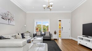 A modern living room with a sofa, coffee table, TV stand, and a decorative vase.