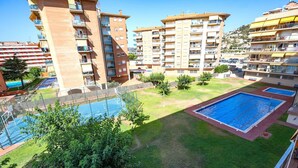 A residential area with multiple apartment buildings, a swimming pool, and a tennis court. - Lovely apartment for 4 people with WIFI, pool, A/C, TV and balcony (Santa Susanna)
