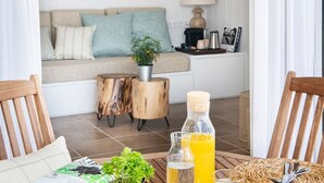 A cozy living area with a sofa, a coffee table with drinks, a mirror, and a lamp. - Appartement DE 1 Chambre (Llançà)