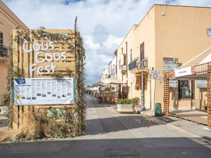 A street with a wooden sign reading "Cous Cous Fest" and a poster with event details. - Beautiful apartment for 5 guests with WIFI, A/C, TV and terrace (San Vito Lo Capo)