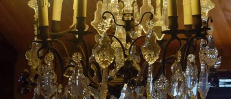 Un candelabro con múltiples luces similares a velas y adornos de cristal.