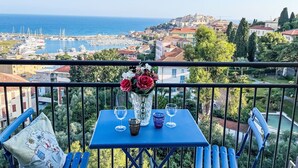 A balcony with a table, two chairs, and a vase of flowers. - Beautiful apartment for 7 people with WIFI and balcony (Imperia)