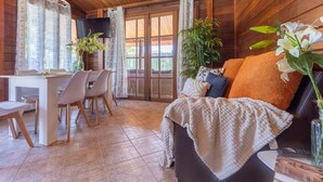 A cozy cabin interior with a dining area, a sofa with a blanket, and a potted plant. - Stunning private villa for 6 people with WIFI, A/C, private pool, TV, patio and pets allowed (Deltebre)
