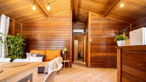 A cozy wooden cabin interior with a dining area, sofa, and potted plants. - Stunning private villa for 6 people with WIFI, A/C, private pool, TV, patio and pets allowed (Deltebre)