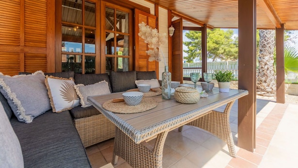 A covered outdoor seating area with wicker furniture, a table, and decorative items. - Stunning private villa for 6 people with WIFI, A/C, private pool, TV, patio and pets allowed (Deltebre)