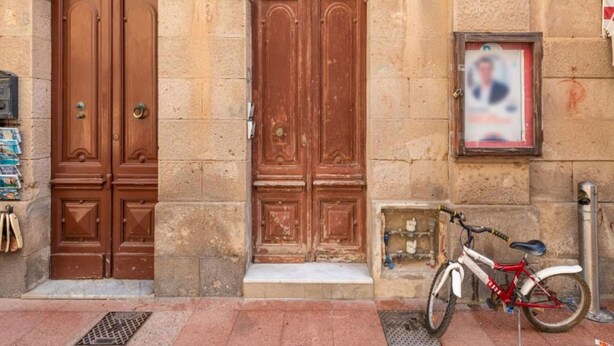 Un bâtiment doté de deux grandes portes en bois, numérotées 38 et 40, et un vélo garé à l’extérieur.