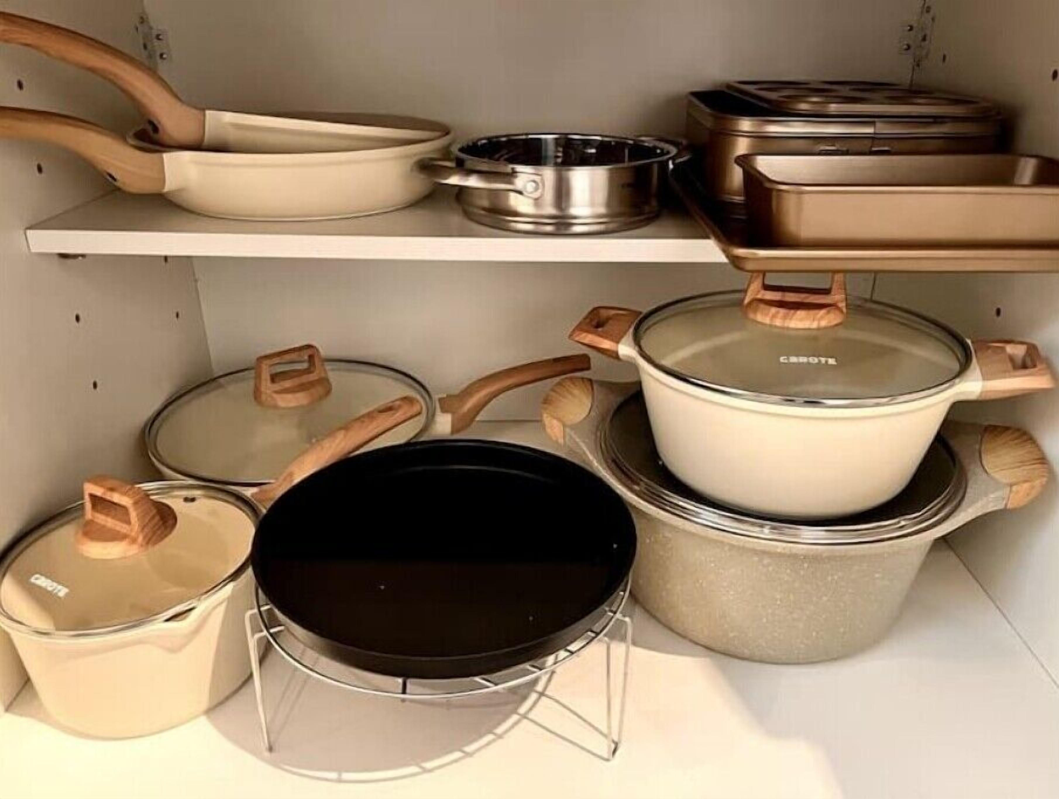 Ein Küchenregal mit diversen Kochutensilien, darunter Töpfe, Pfannen und eine Bratpfanne.