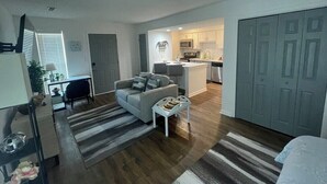 Un apartamento moderno con sala de estar, cocina y comedor separados.