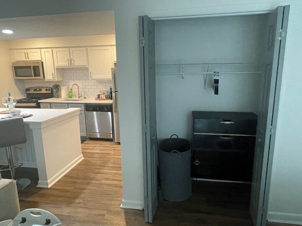 Una cucina moderna con mobili bianchi, un forno a microonde, un piano cottura e una lavastoviglie.